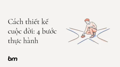 Minh họa cho Cách thiết kế cuộc đời: 4 bước thực hành: Một người đặt một viên gạch nhỏ trên con đường phân nhánh, tượng trưng cho việc chọn hướng đi bằng thử nghiệm và suy ngẫm.